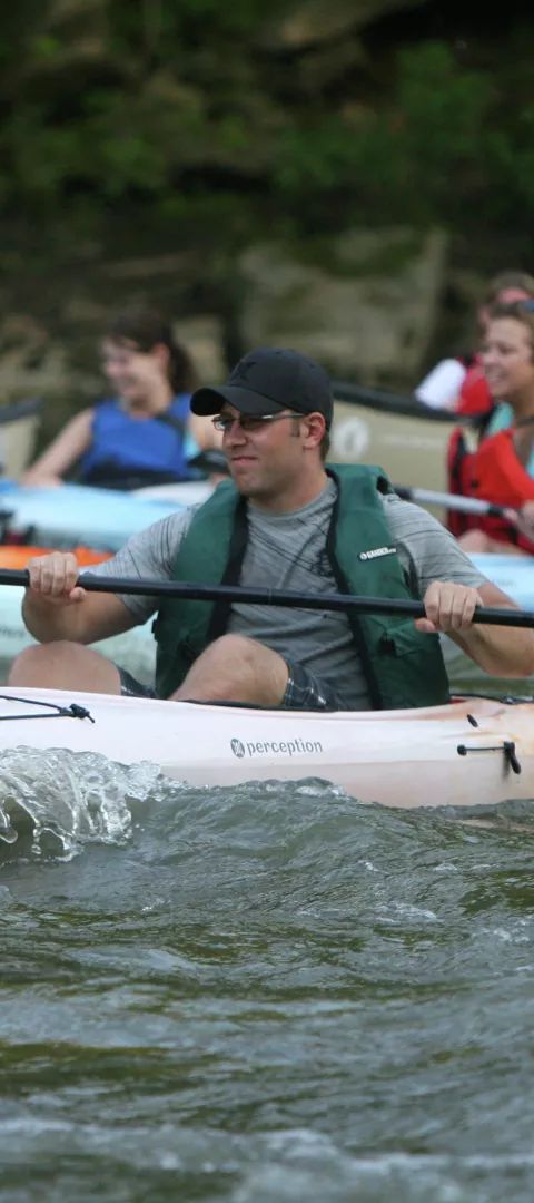 Group kayaking on river rapids