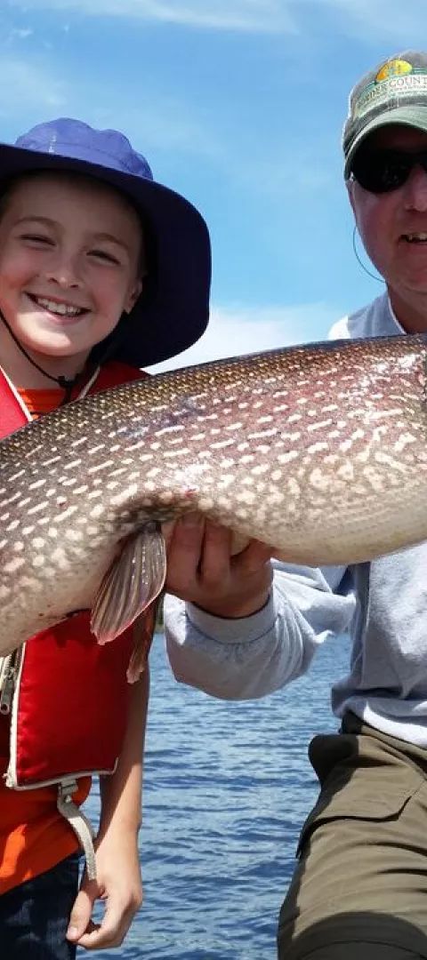 A young girl catches a nice northern pike while fishing in Voyageurs National Park