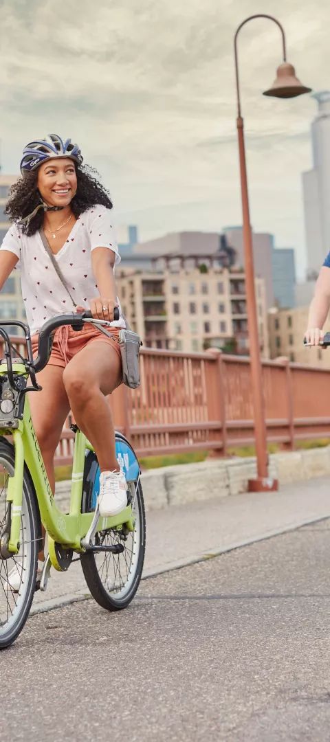 Man and woman biking on the Stone Arch Bridge in Minneapolis